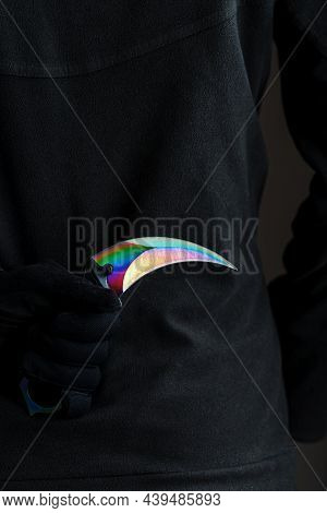 A Criminal With A Sharp Knife Hidden Behind His Back.