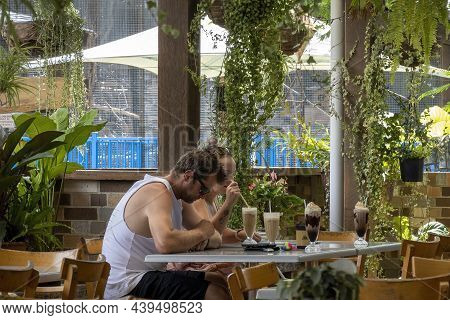 Proserpine, Queensland, Australia - November 2021: Young Couple Enjoying Cold Milk Drinks In Outdoor
