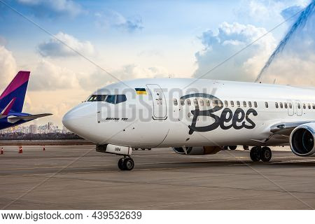 Bees Airline Yellow Plane On The Apron. Boeing 737-800 Ur-uba Passenger Aircraft. After Rain And Was