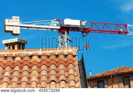 Red And White Tower Crane And A Closeup Of A Roof With Terracotta Tiles (coppo In Italian Language) 