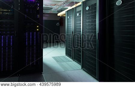 Data center with multiple rows of fully operational server racks. modern cloud computing technology concept.