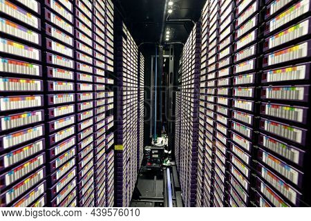 Data center with multiple rows of fully operational server racks. modern cloud computing technology concept.
