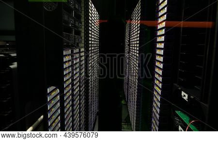 Data center with multiple rows of fully operational server racks. modern cloud computing technology concept.