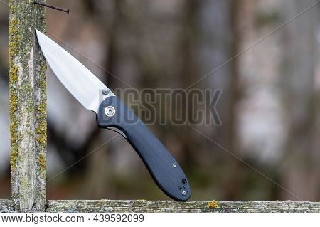 Knife In The Window Frame. Knife In A Wooden Frame. Plastic Knife With Black Plastic Handle.