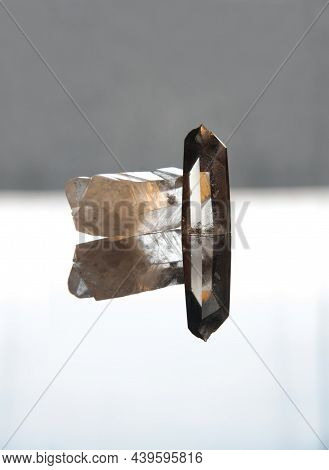 Hyaline Quartz And Smoky Quartz Stones, On Bright Background. Natural Reflected In Plan. Mirror Effe