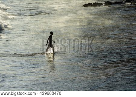 Man Slowly Coming Out Of The Sea From The Beach Of Ondina After Bathing.