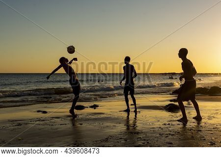 Young People Playing Sand Football At Sunset On Ondina Beach
