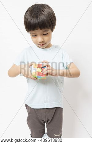 Asian Cute Kid Play With Rubic On White Background.