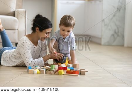 Happy Babysitter And Cute Preschool Boy Playing Games On Floor