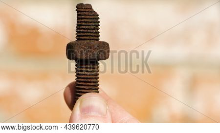 Old Rusty Bolt, Iron Rod With Screw Threads, In Hand. Rusted Mechanical Components. Holding Threaded