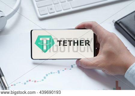Russia Moscow 08.06.2021 Man Holding Logo Of Tether Usdt Token In Mobile Phone. Cryptocurrency Stabl
