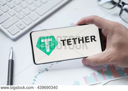 Russia Moscow 08.06.2021 Man Holding Logo Of Tether Usdt Token In Mobile Phone. Cryptocurrency Stabl