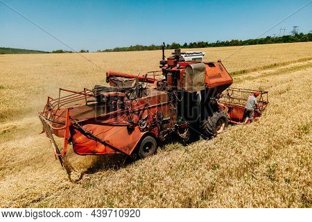 Farmer Rides An Old Combine To Work. Combine Harvester Goes On Way To Harvest Wheat. Top View Aerial