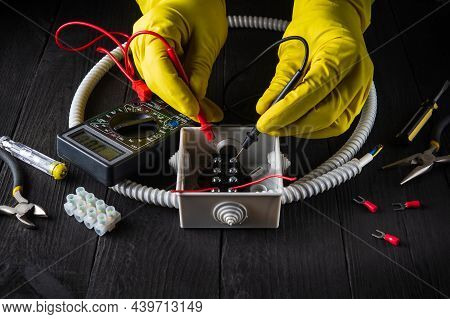 Electrician Uses A Tester To Check The Contacts In The Junction Box. Working Environment In The Mast