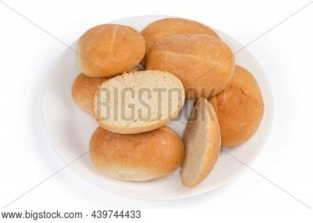Pile Of Whole Small Round Slightly Oblong Buns And One Bun Cut Horizontally On The White Dish On A W
