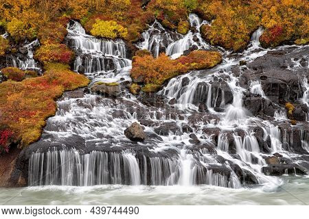 Hraunfossar or Lava Falls, Snaefellsnes peninsula, Iceland. This fairytale location sees multiple waterfalls cascading through vocanic rock. The autumn colours of  add to the magic. 