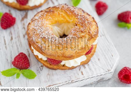Choux Pastries. Choux Rings With Cream Of Cream Cheese Or Cottage Cheese And Fresh Raspberries, Dust