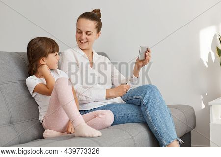 Positive People Posing Indoor At Home, Having Video Call, Woman Holding Smart Phone In Hand And Look