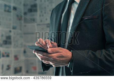 Businessman Using Mobile Phone In Fake News Infodemic Concept With Tabloid Newspaper Pages In Backgr