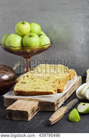 Sliced Apple And Coconut Oaf Cake On Wooden Cutting Board On Dark Background