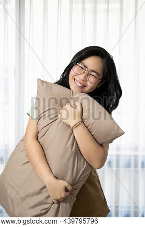 Glasses Beautiful Asian Woman Is Hugging Her Pillow And Smiling To The Camera In The Bedroom With A 
