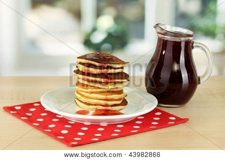 หวาน pancakes บนแผ่นกับแยมบนโต๊ะในห้องครัว