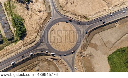 Top Down Aerial View Of A Traffic Roundabout. Roundabout Traffic Of Cars And Trucks On The Circle Ri