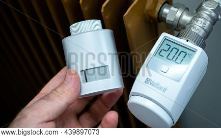 Paris, France - Apr 21, 2021: Pov Male Hand Holding Netatmo Radiator Thermostatic Head Next To The V
