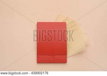 Package With Facial Oil Blotting Tissues On Beige Background, Flat Lay. Mattifying Wipes