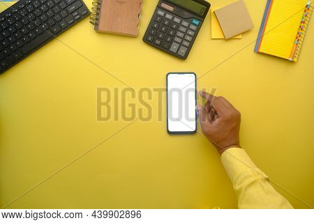 Top View Of Man Hand Using Smart Phone On Office Desk