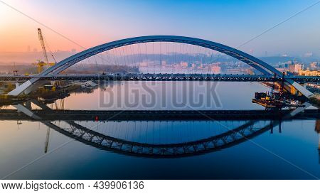 Aerial View Of The New Railway Bridge, Which Is Reflected Over The Calm River Dnieper Before Dawn In