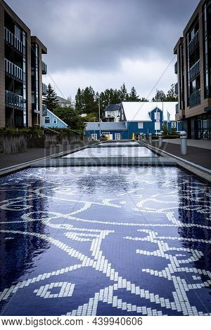Hafnarfjordur, Iceland - July 17, 2021: Two Dark Blue, Decorative Water Pools In The Town Center, Be
