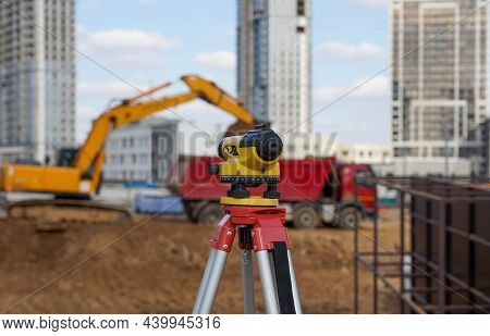Photo Of A Level At The Construction Site Of Multi-storey Buildings With A Yellow Excavator And An R