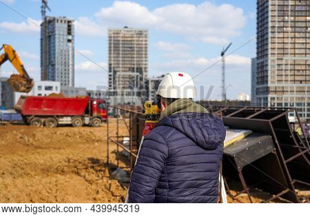 Photo Of A Construction Worker In A White Helmet Who Looks Into The Level At The Construction Site O