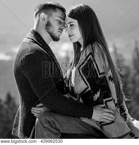 A Loving Couple Wrapped In A Blanket Sitting On The Veranda Of A Mountain Villa On The Background Of