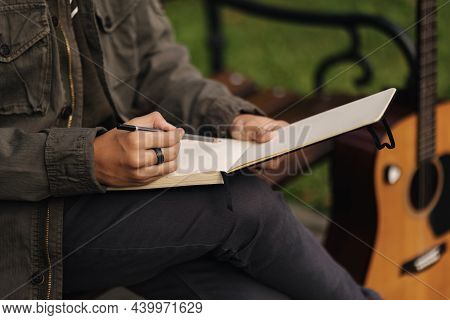 Talanted Person Is Talanted In Everything. Teenager Writes Lyrics For A Song. Boy Using Acoustic Gui