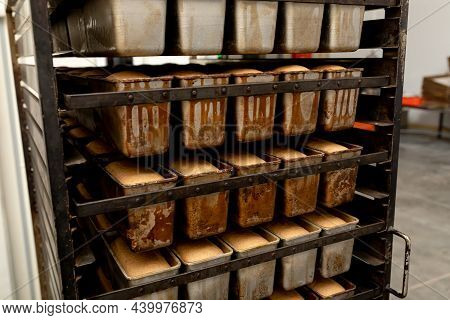 Fresh Bread On A Mobile Rack With Shelves. Metal Racks With Freshly Baked Loaves Of Fresh Wheat Brea