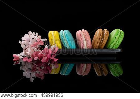 An Assortment Of Magaroons On Black Background With Beautiful Reflections.