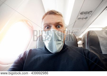 Afraid Of Fear Flying On Airplane And Height Tourist Man In Safe Medical Mask. Concept Aerophobia Or