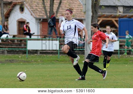 KAPOSVAR, HUNGARY - NOVEMBER 3: Kata Recsei (white 13) in action at Hungarian Championship under 15 women soccer game Rakoczi FC (white) vs Pecsi MFC (red) November 3, 2013 in Kaposvar, Hungary.