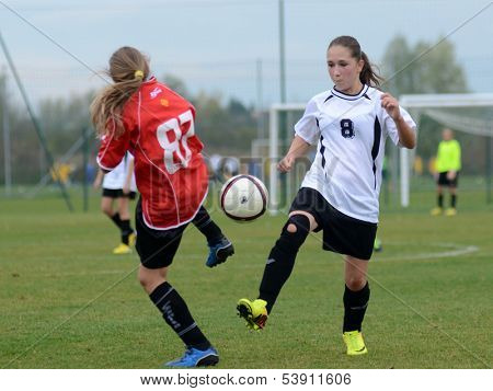 KAPOSVAR, HUNGARY - NOVEMBER 3: Csenge Ujvari (white 8) in action at Hungarian Championship under 15 women soccer game Rakoczi FC (white) vs Pecsi MFC (red) November 3, 2013 in Kaposvar, Hungary.