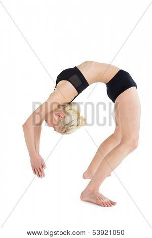 Full length side view of a fit young woman bending backwards over white background