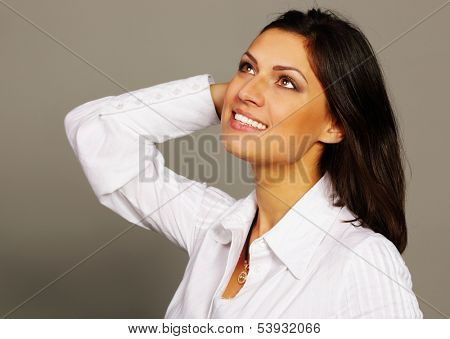 Portrait of a happy beautiful woman touching her hair and looking up