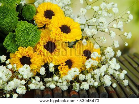 Beautiful flowers on table on bright background