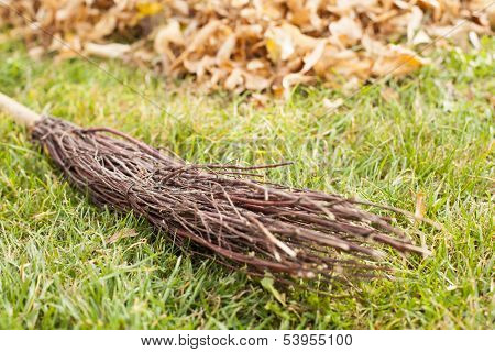 Fall clearing in garden - besom and a pile of leaves
