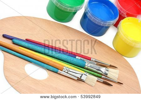 Painter's palette with paintbrushes and colors on white