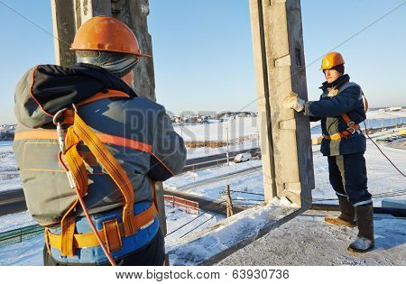 Team of builder worker in safety protective equipment at winter construction site