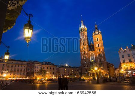 KRAKOW, POLAND - APR 7, 2014: St. Mary's Church on Rynek Glowny (Market Square) in night time. Rynek Glowny - roughly 40,000 m2 is largest medieval town square in Europe.