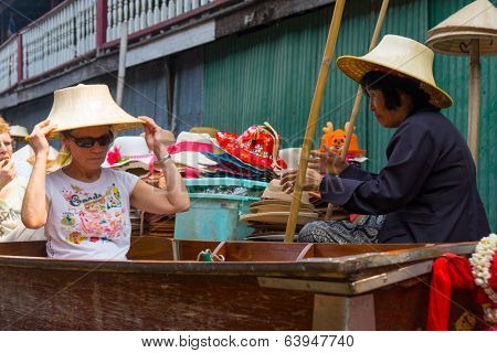 RATCHABURI, THAILAND - MARCH 24: Local peoples sell fruits, food and souvenirs at famous tourist attraction Damnoen Saduak floating market on March 24, 2014 in Ratchaburi, Thailand.