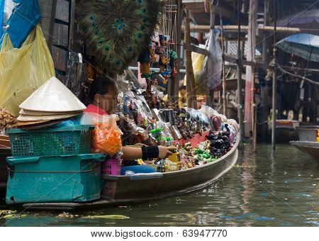 RATCHABURI, THAILAND - MARCH 24: Local peoples sell fruits, food and souvenirs at famous tourist attraction Damnoen Saduak floating market on March 24, 2014 in Ratchaburi, Thailand.